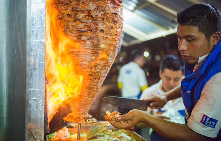 A Mexico City Street food vendor preparing tacos al pastor